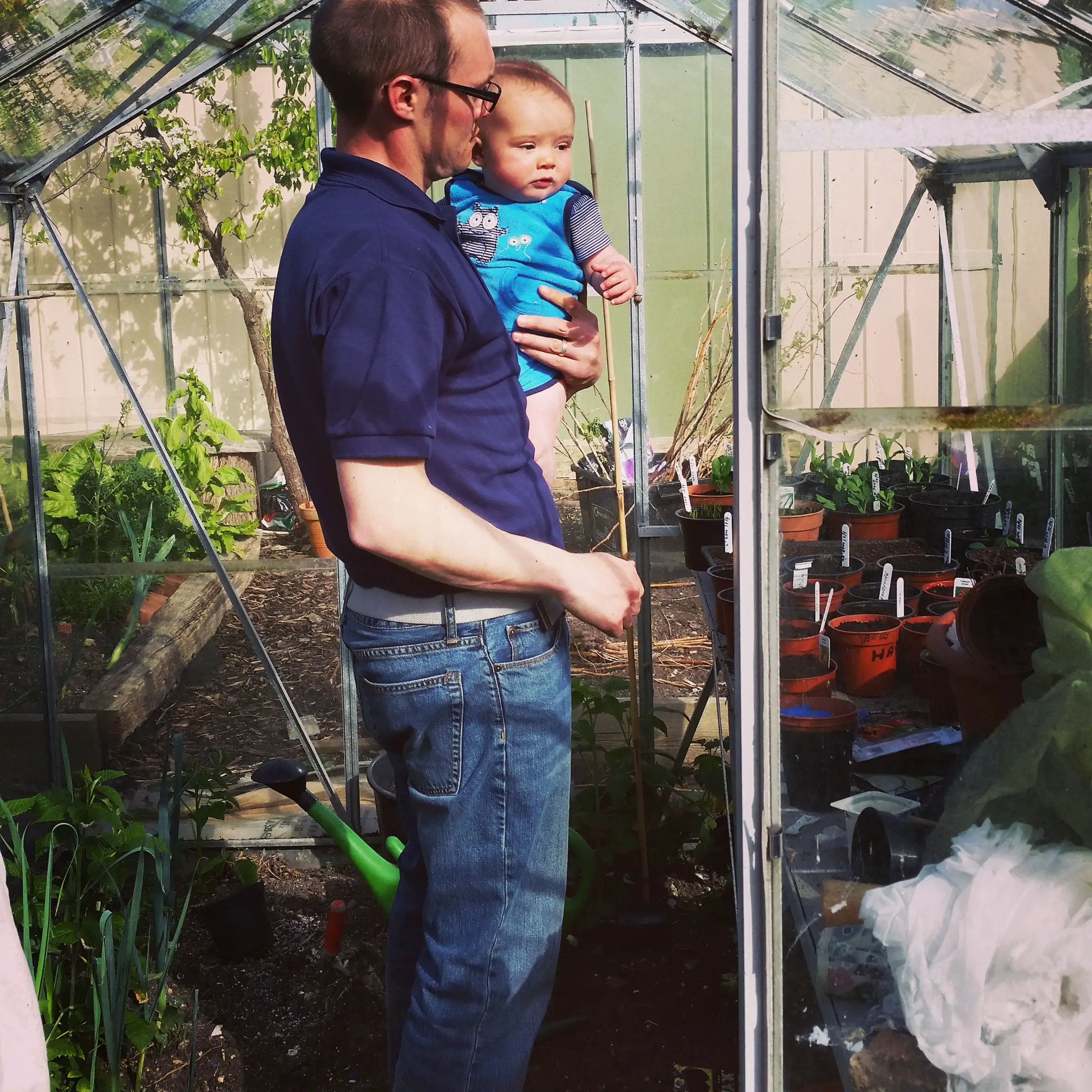 father and son standing in the old greenhouse